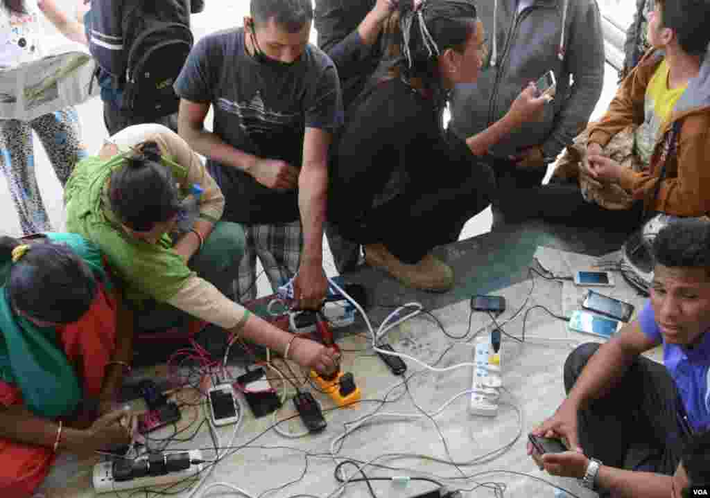 Residents of the Kathmandu district of Anaam Nagar and surrounding areas charge their mobiles at Singha Durbar, the seat of government, after households lost electricity after the earthquake on Saturday, April 27, 2015. (Bikas Rauniar/VOA)