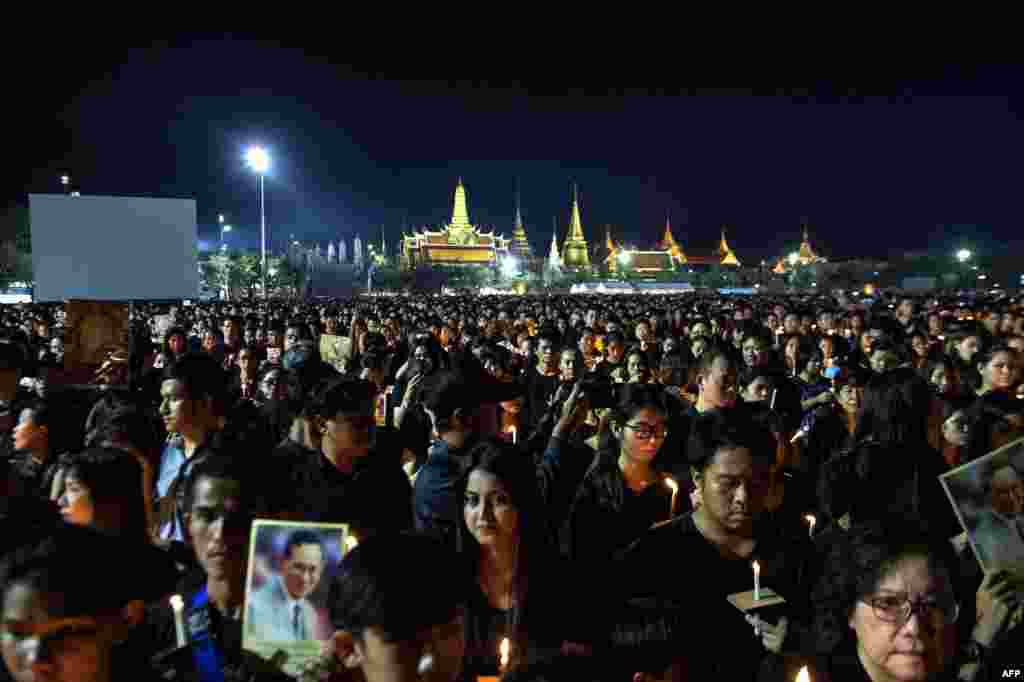 Mourners clad in black light candles for late Thai King Bhumibol Adulyadej at the Sanam Luang Park outside the Grand Palace in Bangkok, Oct. 22, 2016.