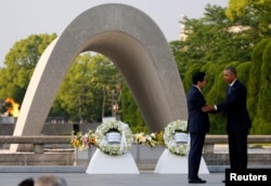 FILE - U.S. President Barack Obama puts his arm around Japanese Prime Minister Shinzo Abe after they laid wreaths in front of a cenotaph at Hiroshima Peace Memorial Park in Hiroshima, Japan. May 27, 2016.