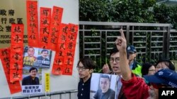 FILE - Hong Kong pro-democracy activists hold a placard, at right, that reads "rights activism is not wrong, free Huang Qi" during a protest outside the Chinese Liaison Office in Hong Kong, Jan. 29, 2019. 