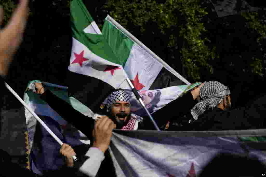 Los sirios en Chipre ondean banderas durante una manifestación espontánea que celebra la caída del régimen de Assad, en la plaza Eleftheria de la capital, Nicosia, Chipre, el domingo 8 de diciembre de 2024.