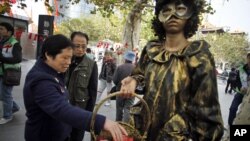 Passerby pick up condoms during an AIDS awareness event held by local community on the International AIDS Day in Shanghai, China, December 1, 2011. (AP)
