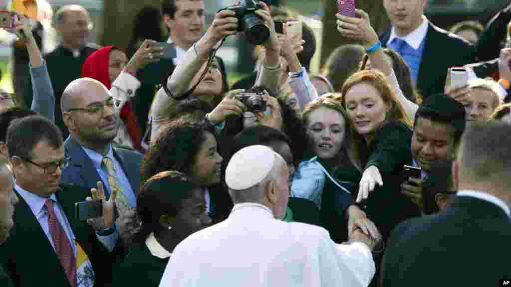 Pope Francis greets well-wishers while departing for the White House from the Apostolic Nunciature, the Vatican's diplomatic mission in Washington, Sept. 23, 2015.