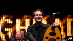 Iraqi virtuoso oud player Naseer Shamma prepares to perform with an orchestra, at the Iraqi National Theater in Baghdad, Iraq, Friday, Jan. 21, 2022. (AP Photo/Hadi Mizban)