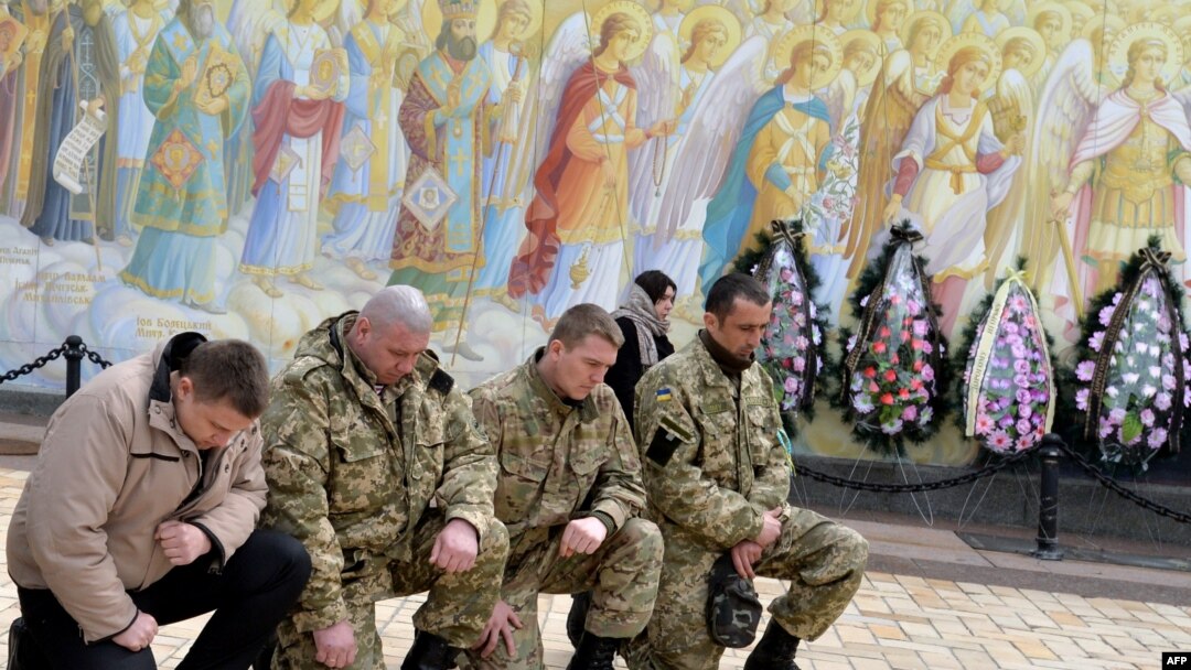 Sahabat-sahabat yang berduka cita memberikan penghormatan terakhir pada tentara Ukraina, Igor Branovitsky, 38, yang tewas dalam pertempuran di Ukraina Timur, di Kyiv (3/4). (AFP/Genya Savilov)