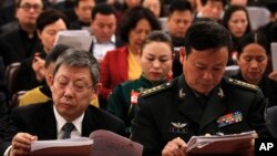 Delegates read the work reports which is delivered by Chinese Premier Li Keqiang at the opening session of the annual National People's Congress at the Great Hall of the People in Beijing, Tuesday, March 5, 2019. 