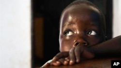 In this photo taken Friday, April 27, 2012, in Gulu, Uganda, Betty, 3, looks up at her mother Adye Sunday, 25, unseen, who was abducted when she was 13 by Lord's Resistance Army leader Joseph Kony and forced to be one of his dozens of "wives." She says he's also the father of her two children 