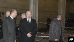 Belarus President Alexander Lukashenko, center, accompanied by his bodyguards, looks at the blast site inside the Oktyabrskaya subway station in Minsk, Belarus, April 11, 2011