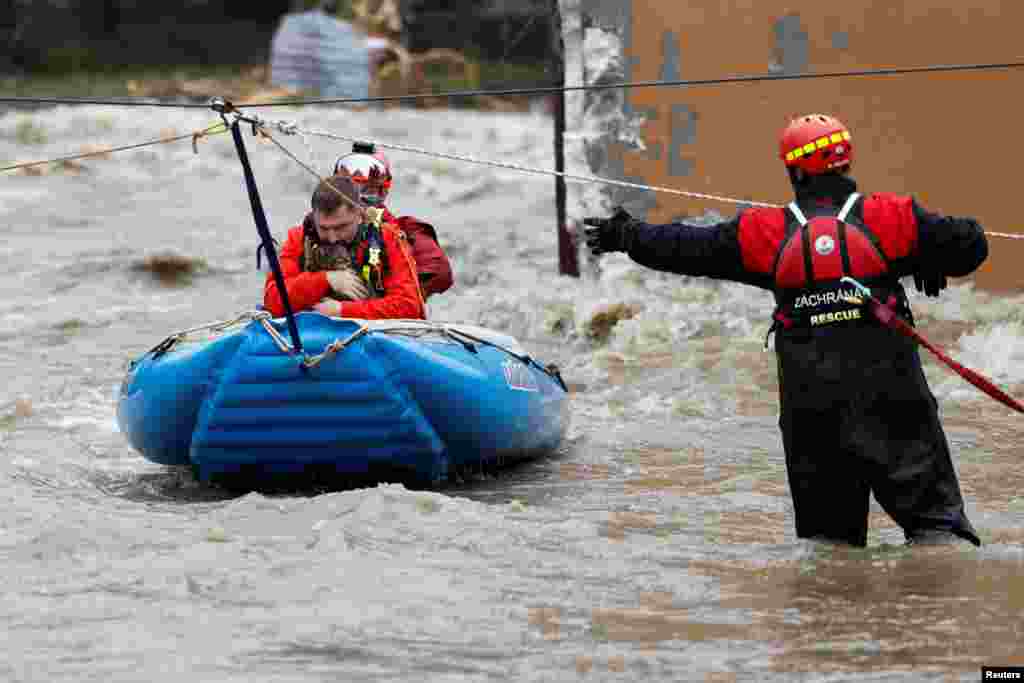 A man holds a cat as he is evacuated by rescuers on a flooded street, following heavy rainfall in Jesenik, Czech Republic.