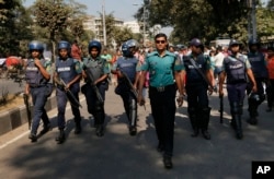Bangladeshi policemen guard the scene as activists campaigning for capital punishment for war criminals protest a nationwide strike called by the main Islamist party, Jamaat-e-Islami, Nov. 23, 2015, in Dhaka, Bangladesh.