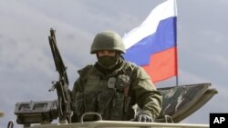 На Фото: Військовий на фоні триколору 2014-й рік. Перевальне, Крим.