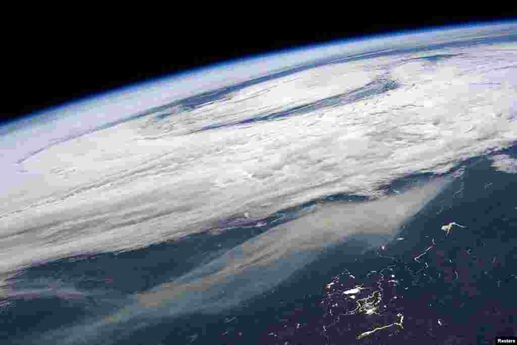 The smoke plume (bottom) from large wildfires in and around Ft McMurray, Alberta, Canada is seen in a picture taken by NASA astronaut Jeff Williams from the International Space Station.