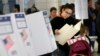 FILE - A woman looks over her ballot at a polling station in the Washington Heights section of New York, Nov. 8, 2016.