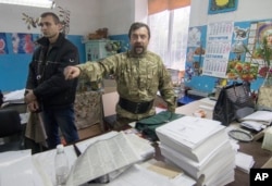 A member of a regional election commission argues during an inspection of voters ballots in a printing house in Mariupol, a major port and steel city in Ukraine's east, Oct. 25, 2015.