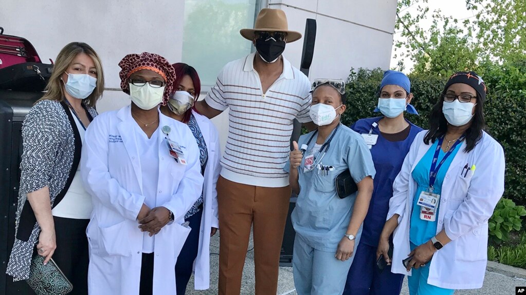 This image released by Damien Escobar shows Escobar with medical staff at Queens Hospital in the Queens borough of New York. Many people are reaching out to help others during the pandemic.