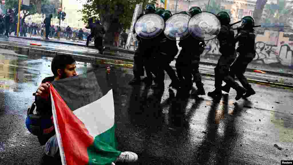 Un manifestante sostiene una bandera palestina cerca de miembros de los Carabineros en una protesta para expresar su apoyo a los palestinos en Gaza, en Roma, Italia, el 5 de octubre de 2024.