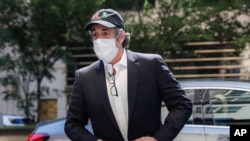 FILE- In this May 21, 2020, file photo, Michael Cohen arrives at his Manhattan apartment in New York after being furloughed from prison because of concerns over the coronavirus.