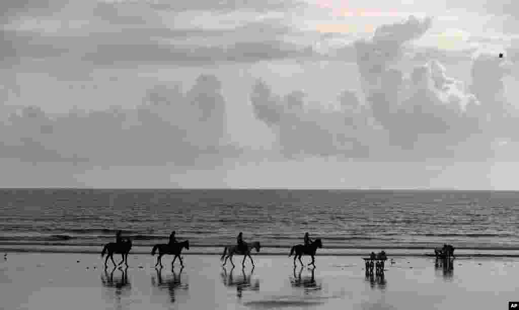 Police officers on horses patrol along the Arabian Sea coast after the 10-day long Ganesh Chaturthi festival, in Mumbai, India.