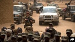 Un soldat français se tient derrière des soldats maliens lors d'une visite du chef de l'opération de Serval de la France à une base de l'armée malienne à Kidal, au Mali, 27 juillet 2013.