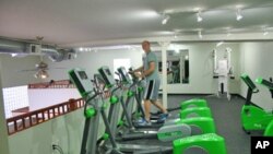 Green Microgym owner Adam Boesel on an elliptical machine that generates electricity during a workout.