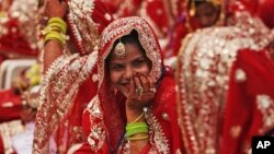 An Indian Muslim bride smiles, as she sits with other brides during a mass wedding organized by a social organization in Ahmadabad, India, Sunday, Feb. 15, 2015. 