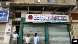 Men stand in front of closed shops near Pearl Square in the center of Manama, Mar 15 2011