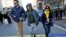 FILE - Boston Marathon bombing survivor Jeff Bauman, center, walks over the marathon finish line on the third anniversary of the bombings, April 15, 2016, in Boston.