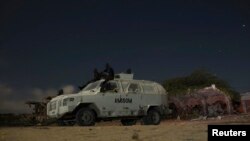 FILE - African Mission in Somalia (AMISOM) soldiers rest on top of an armored vehicle during a break on a street patrol with local police at the old stadium in Mogadishu, Somalia, Nov. 14, 2013.