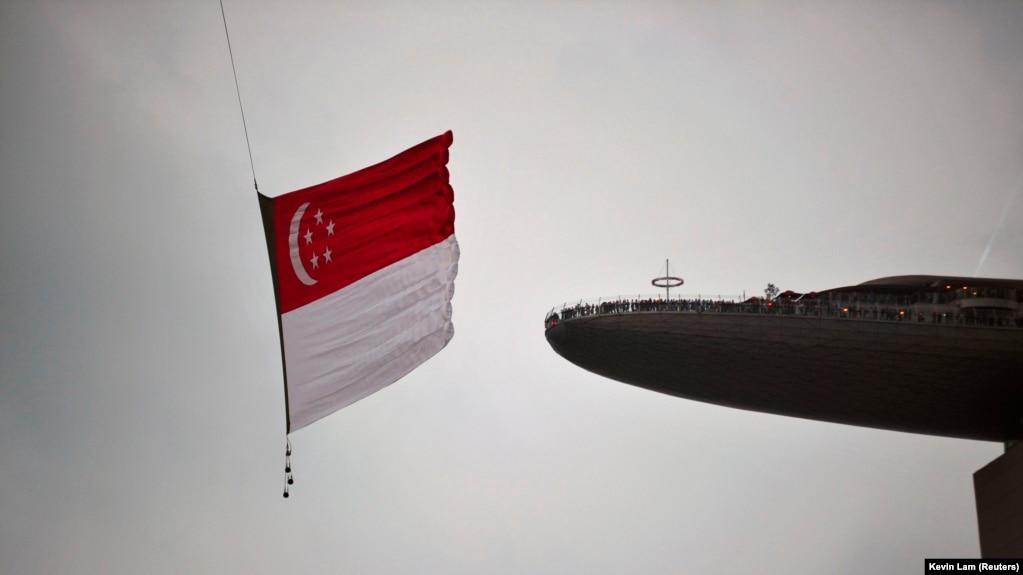 Bendera nasional Singapura dikibarkan oleh helikopter Chinook CH-47SD. Singapura akan memberlakukan "sanksi dan pembatasan yang pantas" pada Rusia.(Foto: REUTERS/Kevin Lam)