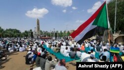 Des manifestants pro-militaires soudanais écoutent le sermon de la prière du vendredi, en présence du ministre des Finances, devant le palais présidentiel à Khartoum, le 22 octobre 2021.