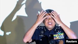 El jefe de la policía malasia, Khalid Abu Bakar, demuestra a los periodistas cómo se untó de una sustancia tóxica el rostro de Kim Jong Nam.