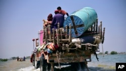 FILE: Victims of flooding from monsoon rains carry belongings salvaged from their flooded home in Pakistan, Friday, Sept. 9, 2022. Secretary-General Antonio Guterres appealed to the world for help for Pakistan after seeing the devastation from months of deadly record floods.