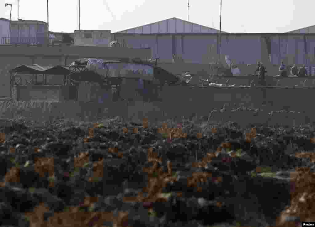 Foreign security forces stand at the site of a blast in a base for foreign forces in Kabul, Nov. 18, 2014.