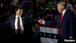 Ohio Senator Troy Balderson shakes hands with U.S. President Donald Trump during a Make America Great Again rally in Olentangy Orange High School in Lewis Center, OH, Aug. 4, 2018.