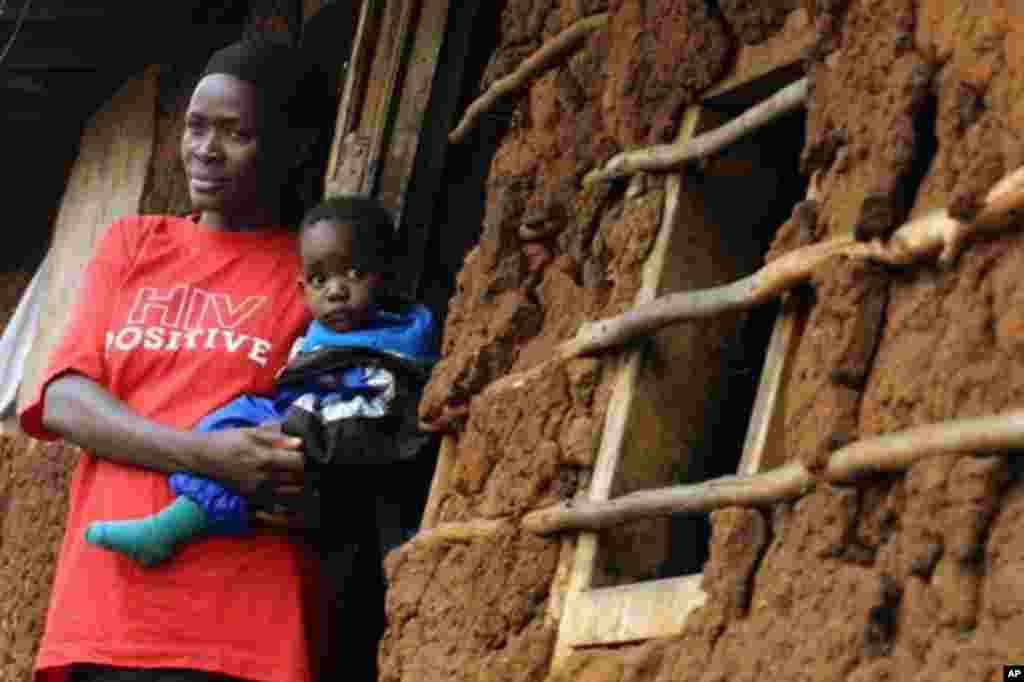 Muathirwa wa HIV akimbeba mwanawe katika kitongoji cha Kibera, Kenya