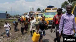 FILE - Congolese people carry their belongings as they flee from their villages around Sake in Masisi territory, following clashes between M23 rebels and the Armed Forces of the Democratic Republic of the Congo,February 7, 2024.