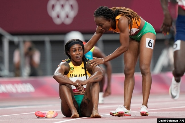 La sprinteuse ivoirienne Marie-Josée Ta Lou félicite Elaine Thompson-Herah, de la Jamaïque, après la finale du 200 mètres féminin aux Jeux olympiques d'été de 2020, mardi 3 août 2021.