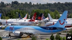 Dozens of grounded Boeing 737 MAX airplanes crowd a parking area adjacent to Boeing Field Thursday, Aug. 15, 2019, in Seattle. Aviation authorities around the world grounded the plane in March after two fatal crashes. (AP Photo/Elaine Thompson)