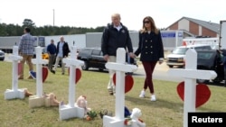 El presidente de Estados Unidos, Donald Trump, y la primera dama, Melania Trump, llegan para ver una fila de cruces de las víctimas del tornado en Beauregard, Alabama, EE. UU.