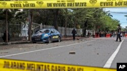 Anggota polisi penjinak bom memeriksa area sekitar lokasi serangan bom bunuh diri hari Minggu di Katedral Hati Kudus Yesus di Makassar, Sulawesi Selatan, Indonesia, Senin, 29 Maret 2021. (AP Photo/Yusuf Wahil)
