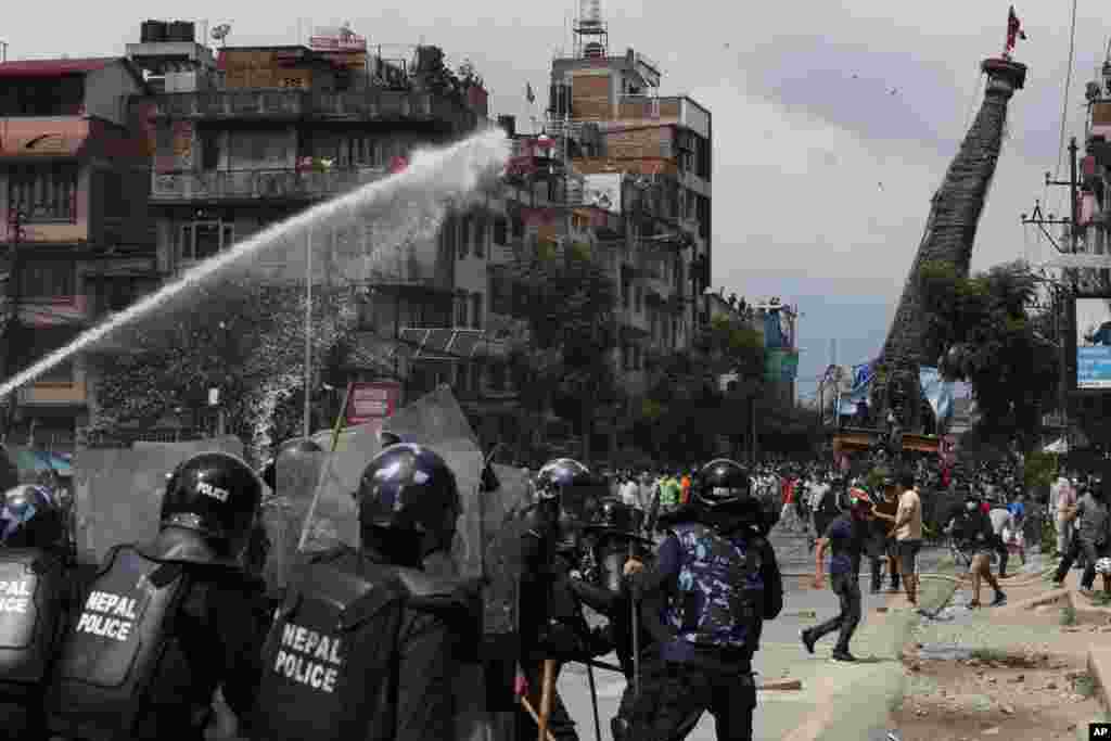 Nepalese protesters defying a government coronavirus lockdown to take part in a religious festival, clash with riot police, in Lalitpur.