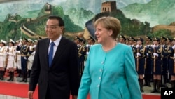 Germany's Chancellor Angela Merkel, right, chats with China's Premier Li Keqiang during a welcome ceremony at the Great Hall of the People in Beijing, Monday, June 13, 2016.