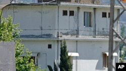 Pakistani children walk past the house of former al-Qaida leader Osama bin Laden in Abbottabad, Pakistan (File Photo - May 8, 2011)