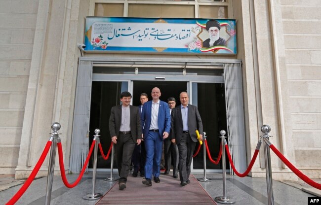 FIFA President Gianni Infantino, center, walks with Iranian Football Federation President Mehdi Taj, right, during his visit to the capital Tehran, March 1, 2018.