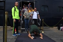 A passenger reacts as he disembarks from the Westerdam cruise ship in Sihanoukville, Cambodia, where the liner docked after being refused entry at other Asian ports due to fears of the COVID-19 coronavirus outbreak.