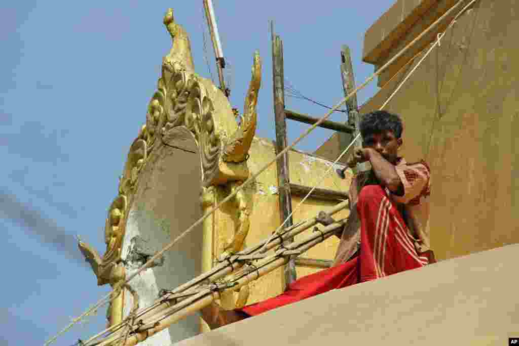 Man repairing pagoda at Buddhist temple overlooking Myitsone, Burma, March 31, 2012. (VOA - D. Schearf)