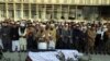 Villagers offer prayers over the coffin of Mohammad Yousuf Rasheed, executive director of the nongovernmental Free and Fair Election Forum of Afghanistan, during his funeral, in Kabul, Afghanistan, Dec. 23, 2020.