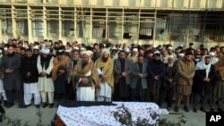 Villagers offer prayers over the coffin of Mohammad Yousuf Rasheed, executive director of the nongovernmental Free and Fair Election Forum of Afghanistan, during his funeral, in Kabul, Afghanistan, Dec. 23, 2020.