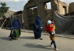 Perempuan Afghanistan dengan burqa dan anak-anak berjalan di jalan di Kabul, Afghanistan, Minggu, 22 Agustus 2021. (Foto: AP)