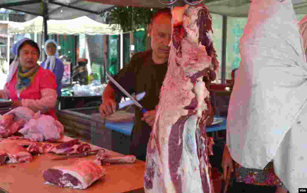 Butchers cut halal meat at a stand near Na Jia Hu Mosque. In its bid to attract Muslim trade, Yinchuan has focused on the production and sale of halal food. (Stephanie Ho/VOA)